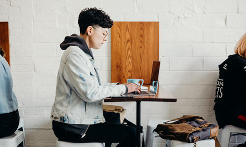 Student working on a laptop in a coffeeshop
